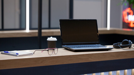 Workplace with a laptop, Notepad and pen, in the distance are headphones and a cardboard