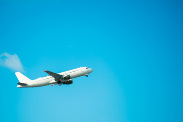 Big white flying plane on blue sky and clouds background