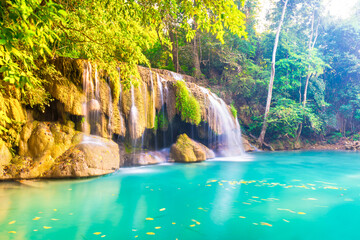 Fototapeta na wymiar Tropical landscape with beautiful waterfall, wild rainforest with green foliage and flowing water. Erawan National park, Thailand