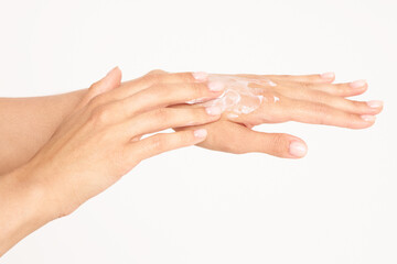 Female hands with cream. Close up of female hands applying cream on a white background