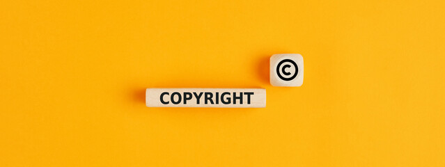 The word copyright and copyright symbol on wooden blocks. Concept of patenting. or copyright...