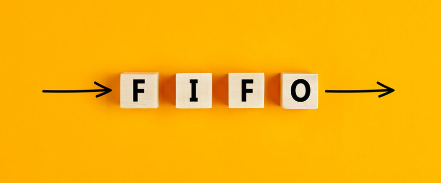The business abbreviation fifo (first in first out) written on wooden blocks with directional arrows