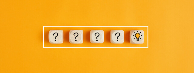 The process of problem solving or idea formation. Question mark and light bulb icons on wooden...