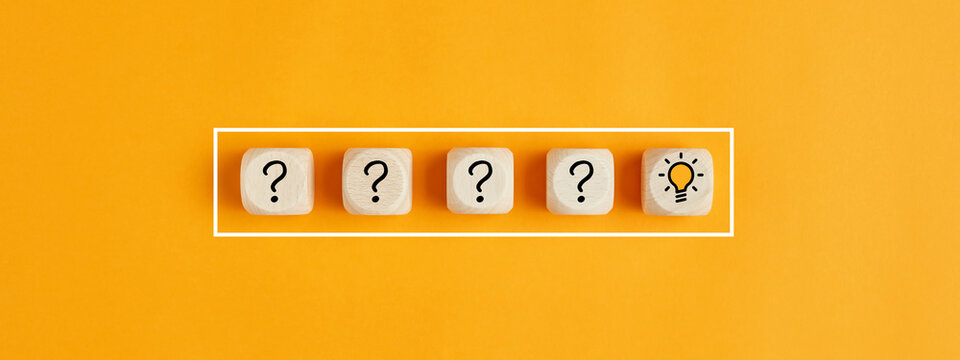 The process of problem solving or idea formation. Question mark and light bulb icons on wooden cubes on yellow background.