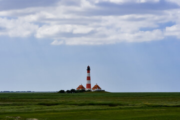 Fototapeta na wymiar The famous lighthouse in Westerhever with a great sky and clouds