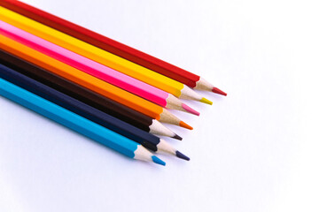 Colored pencils on a white background. Variety of colors. School supplies.