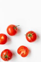 A lot of fresh ripe red tomatoes on white background with copy space, flat lay. Vertical photo