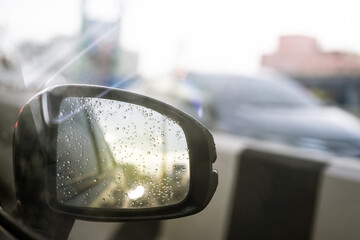 Traffic jam on highway during the rain from side view mirror close up with copyspace. 