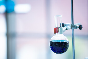 Blue color liquid chemical in a experimental glass wear in the laboratory close up with copy space. Advance chemical science experiment in lab concept.