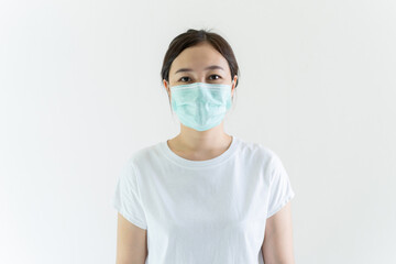 Asian young attractive woman wearing a protective hygiene mask over her face to protect flu and virus. Unwell influenza in infected woman portrait with yellow background. Covid19 and Coronavirus.