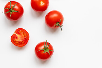 Food composition of many fresh ripe red tomatoes on white background with copy space, flat lay.