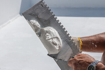 Builder using plastering tool for finishing wall and floor.