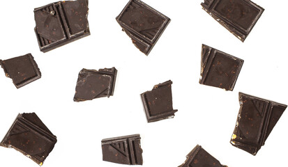Pieces of dark chocolate isolated on white background. Chopped choco bar