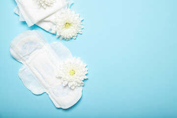 Female cotton pads and flowers on a blue background. View from above