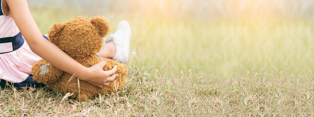 Banner Happy Child hug teddy bear in green park playground. Teddy bear best friend for little girl....