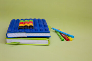 Blue Notepad and pencils isolated on a green background. Place to copy. Concept of school education