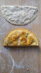 fried and raw cheburek on the table top view