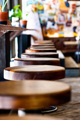 A row of empty bar stools at a restaurant bar counter