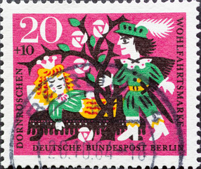 Fototapeta premium GERMANY, Berlin - CIRCA 1964: a postage stamp from Germany, Berlin showing the fairy tale by the brothers Grimm: Sleeping Beauty. The prince comes through the thorn hedge