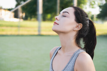 Side view of young beautiful female with closed eyes breathing deeply while doing respiration...
