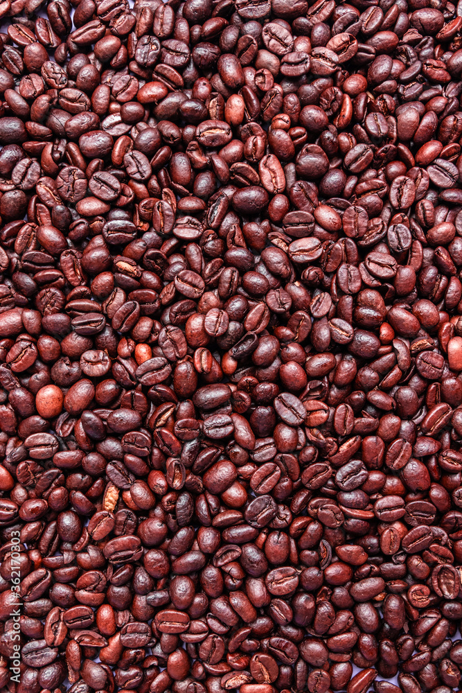 Wall mural Brown roasted coffee beans scattered on the table . Arabic fragrant fried coffee beans close up, top view, flat lay