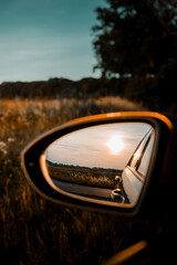 Countryside sunset view in the car side mirror. Harz Mountains, Harz National Park in Germany.