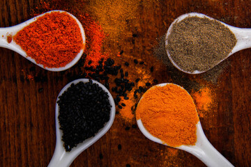 Different types of spices in small dishes with different colors together from the top view.