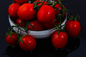 A variety of red tomatoes along with other fruits with a colorful look in the dish.