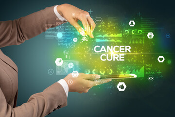 Close-up of a touchscreen with CANCER CURE inscription, medical concept