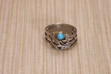 Vintage silver ring with turquoise on a wooden background