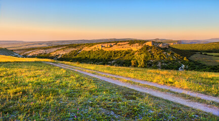 Hilly terrain with ravines and dirt road