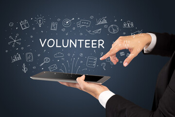 Close-up of a touchscreen with VOLUNTEER inscription, social media concept