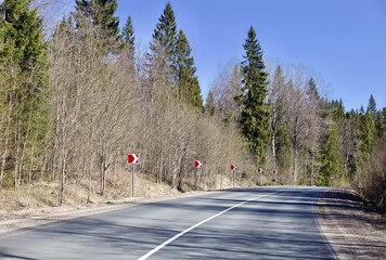 Empty asphalt road turn. Modern countryside road leading into the distance through the forest....