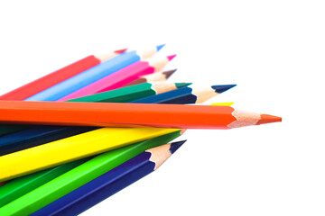 A pile of different colored wood pencil crayons scattered across a white background