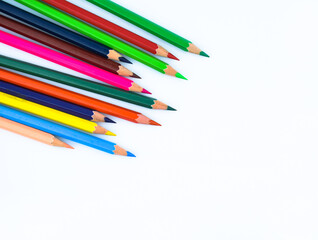 Close up picture of stack of different colored wood pencil crayon on a white background