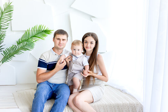 young mom and dad holding a child, parents with a child in a photo Studio, family da, happy familyy