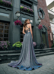 Beautiful elegant fashion model young woman posing. City street, modern building. Brunette girl...