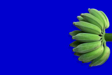 bunch of green bananas isolated on bright navy background