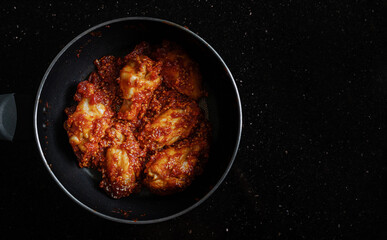Spicy fried chicken, Korean style, in frying pan 