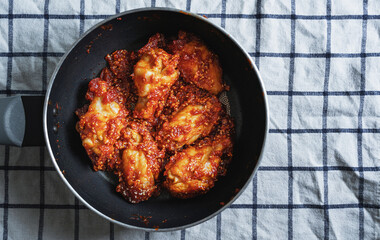 Spicy fried chicken, Korean style, in frying pan 