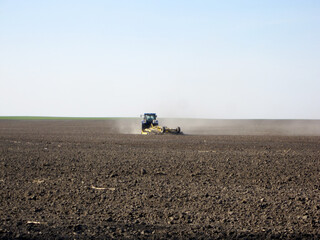 Plowed field by tractor in brown soil on open countryside nature