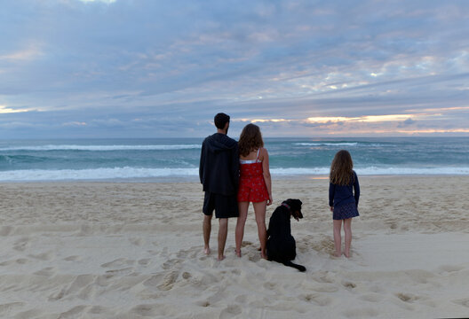 family watching a beautiful sunset on the beach