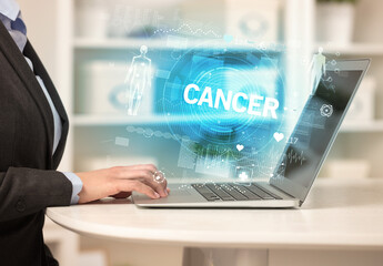 Doctor working a health check with CANCER inscription, recording medical test results