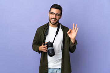 Fototapeta premium Photographer man over isolated purple background showing ok sign with two hands