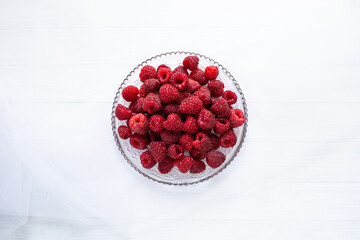 Raspberries on a plate white background 