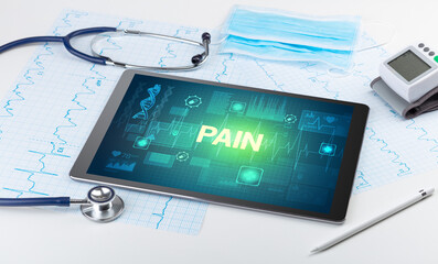 Tablet pc and medical stuff with PAIN inscription, prevention concept