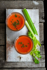 Gaspacho soup - Spanish tomato soup in glasses, ingredients on wooden rustic background.