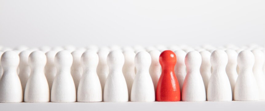 Many White Wooden Figurines And One Red