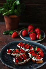 Sandwich with strawberries. With soft cheese and balsamic vinegar. Dark background. Soft focus.