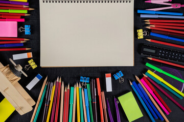 Top view on school educational supplies. Desktop with digital tablet, ruler, pencils, pens, notebooks, magnifying glass and cup of coffee. Studying and researching background, copy space